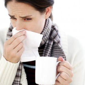 Woman Holding a Mug with a Handkerchief to Her Nose
