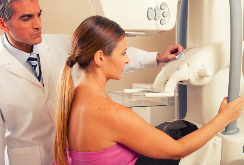 Mulher fazendo o exame de mamografia bilateral.